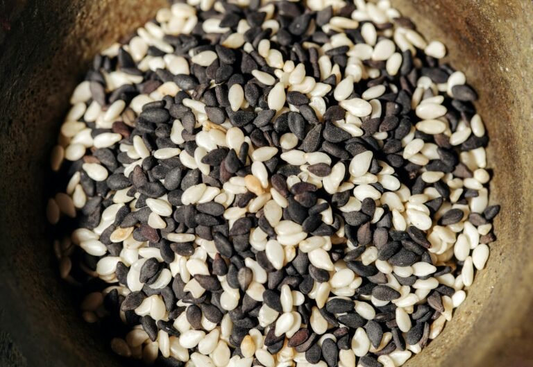 A detailed close-up of black and white sesame seeds in a rustic bowl, perfect for healthy food themes.
